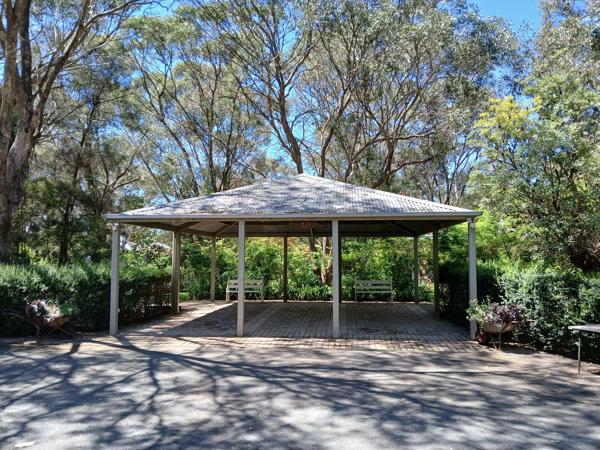 The riverbank pavilion building at Paradise Gardens, shaded by mature greybox trees